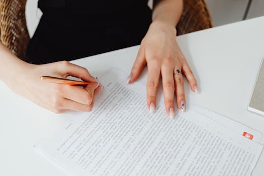 close-up of a hand holding a pen and signing a document