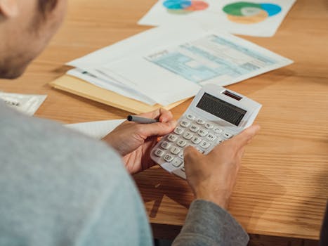 person using a calculator to plan mortgage payments