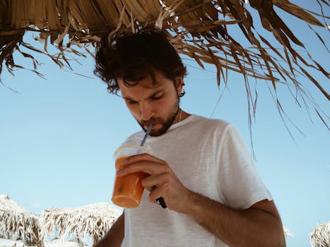 retiree relaxing on a beach with a drink